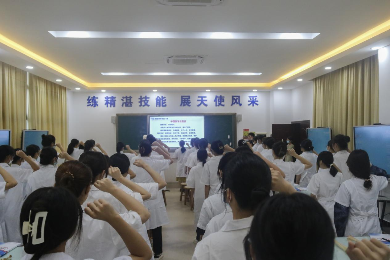 图为 综合办主任黎桂仙带领大家庄严宣誓医学生誓言.png