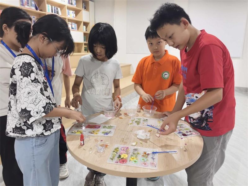 1752639350107768.jpg 图为科创营营员在图书馆学习制作中药水晶滴胶.jpg